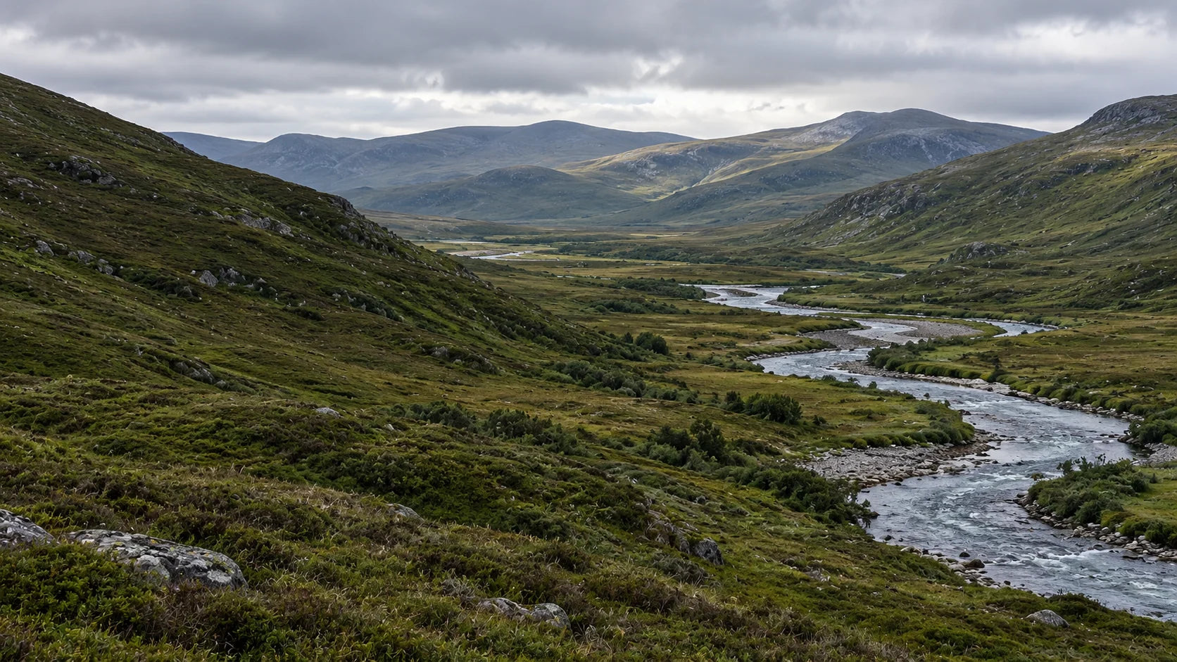 A winding river and layered hills in soft natural light